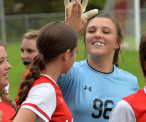 Mya Marshall gives Wiscasset teammate and goalkeeper Addison Eckert a high-five after Wiscasset's 3-0 win over Vinalhaven. (Paula Roberts photo)