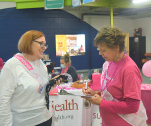 Breast cancer survivor Sue Sidelinger of Damariscotta (right) signs a petition brought by fellow survivor Bethany Zell, of Caribou, calling for broader insurance coverage of testing for common cancer-associated biomarkers at the Making Strides Against Breast Cancer event on Sunday, Oct. 22. With more testing, "people wouldn't have to just try out different treatments to see whether they work," said Zell. (Molly Rains photo)