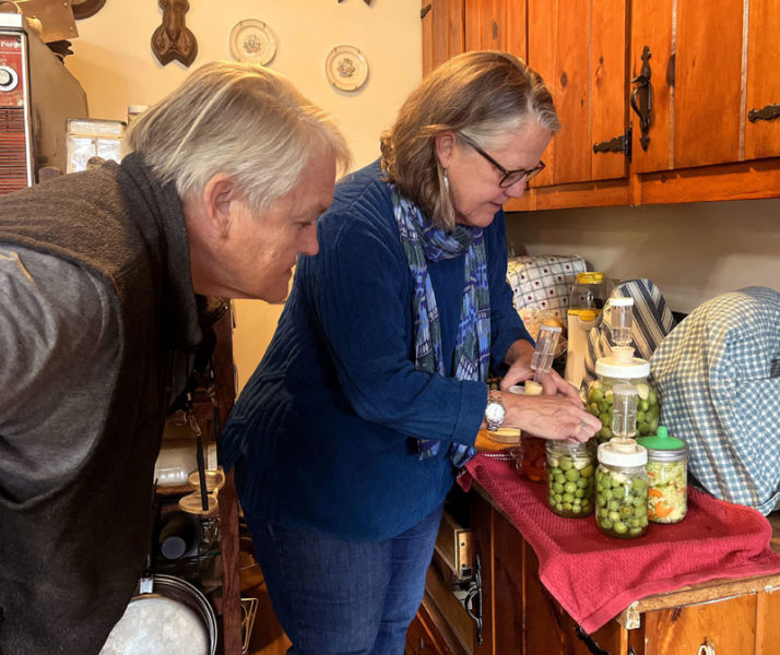 Marge Kilkelly (left) and Mary Kate Reny check on the green tomatoes Kilkelly has been fermenting in her kitchen. One of Reny's favorite food processes is fermenting, which she taught a class about at Kilkelly's farm. (Piper Pavelich photo)