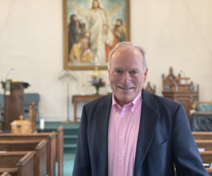 Jeffrey Larsen stands in the aisle between the pews in the Union Church of South Bristol located on Rutherford Island the morning of Monday, Oct. 16. Larsen has been serving as the interim minister since May while the church searches for a permanent replacement for the post. (Johnathan Riley photo)