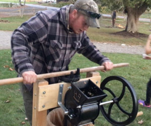 A visitor uses Coastal Rivers Conservation Trusts old-fashioned press to make fresh cider. (Photo courtesy Coastal Rivers Conservation Trust)