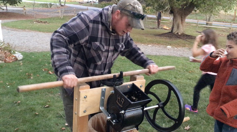 A visitor uses Coastal Rivers Conservation Trusts old-fashioned press to make fresh cider. (Photo courtesy Coastal Rivers Conservation Trust)