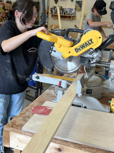 Lincoln Academy student Ariel Cowan works in the school's woodshop to build a cornhole board for the cornhole tournament to benefit Maine veterans, which will take place at the school on Saturday, Nov. 4. (Photo courtesy Lincoln Academy)