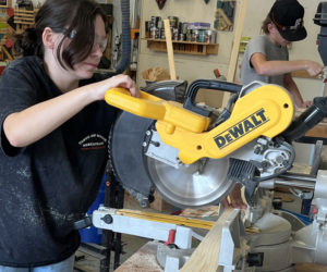 Lincoln Academy student Ariel Cowan works in the school's woodshop to build a cornhole board for the cornhole tournament to benefit Maine veterans, which will take place at the school on Saturday, Nov. 4. (Photo courtesy Lincoln Academy)