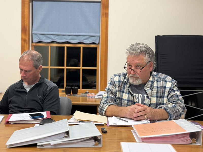 South Bristol Select Board member Robert Clifford (left) reviews documents while Bruce Farrin Jr., the board's chair, listens to an audience member during a meeting on Thursday, Nov. 9. The select board appointed Sandee MacPhee as the interim deputy clerk at the South Bristol town office during the meeting. (Johnathan Riley photo)