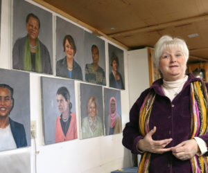 Jerri Whitman stands by portraits she painted of Maine women that have served in the Legislature in her studio at 900 Gardiner Road in Dresden. Whitman is currently working on her first set of portraits for this project, with a goal of finishing 25 portraits by the end of December. (Piper Pavelich photo)