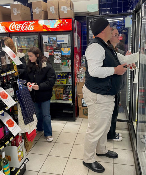 Lincoln Academy students work with Lincoln County Sheriff's Office Chief Deputy Rand Maker during Project Sticker Shock at the Main Street Grocery Wednesday, Dec. 6. (Photo courtesy Jake Abbott)