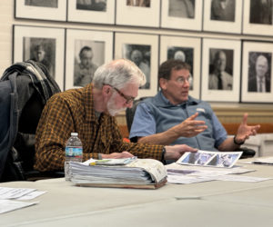 Bristol Select Board member Paul Yates (left) inspects photos presented by Sandee Brackett of her wharf in New Harbor that sustained significant damage during the storms on Jan. 10 and Jan. 13. (Johnathan Riley photo)