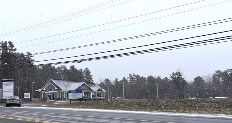 A car enters the Camden National Bank plaza in Damariscotta, which stands alone in land cleared several years ago to house a potential retail development. An initial agreement had developers building a sidewalk along the road to connect with plans for a path from downtown to Great Salt Bay Community School. (Elizabeth Walztoni photo)