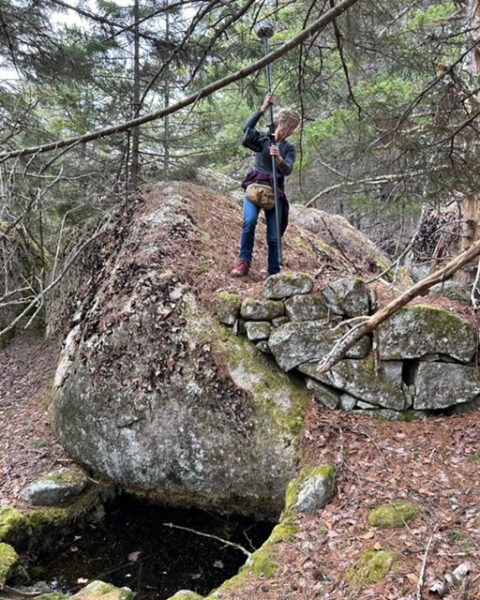 Stephanie Mazerolle examines an old stone wall on Vinalhaven for her work finding property lines with SurveyScapes. Sometimes, she and business partner Anne Howell describe their work as "bushwhacking" in search of clues, but they enjoy the outside experience. (Courtesy photo)