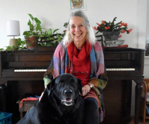 Kaity Newell sits in her music room at home in Damariscotta with her dog, Bruce. A local music teacher in the area for 40 years, she has started or been a founding member of long-lived music institutions Maine Country Dance Orchestra, Oyster Creek Fiddlers, Maine Fiddle Camp, Seacoast Community Orchestra, local contra dances, and the strings program at Great Salt Bay Community School. (Elizabeth Walztoni photo)