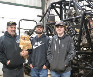 Greg Winchenbach with his sons Zachary and Nathan in front of the chassis of their monster truck, Lumberjack. (Paula Roberts photo)