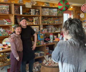 Alexandra Welch, one of the new owners of S. Fernalds Country Store, takes a photo of Pam Jackman and Sumner Fernald Ricky Richards IV on their last day of operation at the store in Damariscotta on Saturday, Feb. 3. (Johnathan Riley photo)