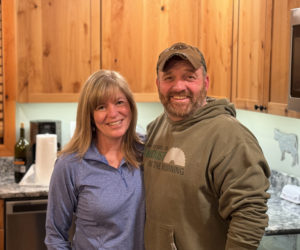 Jarrod and Cheryl Pinkham stand in the kitchen of their Jefferson home on Friday, Feb. 2. The couple, who has been together for nearly 30 years, is active in the Lincoln County community. Jarrod Pinkham, has been involved in local sports as a coach and worked as a code enforcement officer for Edgecomb, South Bristol, Chelsea, and Jefferson, while Cheryl Pinkham has worked at the Damariscotta town office for over 20 years, working as a deputy clerk, town clerk, and, for the last 10 years, as the town treasurer. (Johnathan Riley photo)