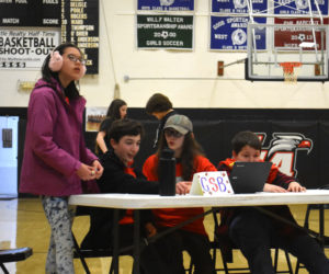 Great Salt Bay Community School's winning Great Maine Book Tournament team considers a question in the Lincoln Academy gymnasium on Tuesday, Jan. 30. They will advance to the regional competition, a success they credited to their librarian, Dawn Greenleaf. "I don't think we could've done it without her," said seventh grader Tristan Greenleaf. (Elizabeth Walztoni photo)