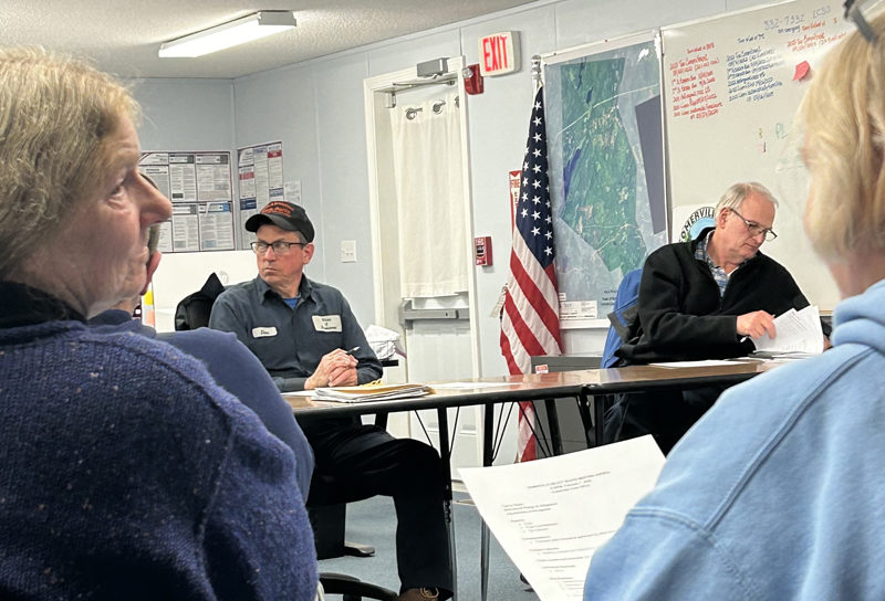 Attendees watch as Somerville Select Board members Don Chase and Donald Whitmer-Kean review correspondence from Delta Ambulance on Wednesday, Feb. 7. (Molly Rains photo)