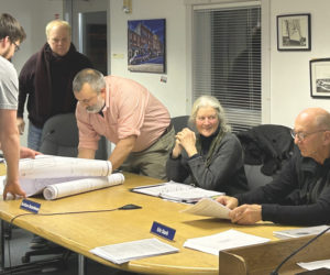 From left: Town Planner Maxwell Johnstone assists Waldoboro Planning Board members John Kosnow, Brendan McGuirl, Barbara Boardman, and Eric Stark in signing the official copies of a 98-acre subdivision planned for Old Augusta Road. (Molly Rains photo)