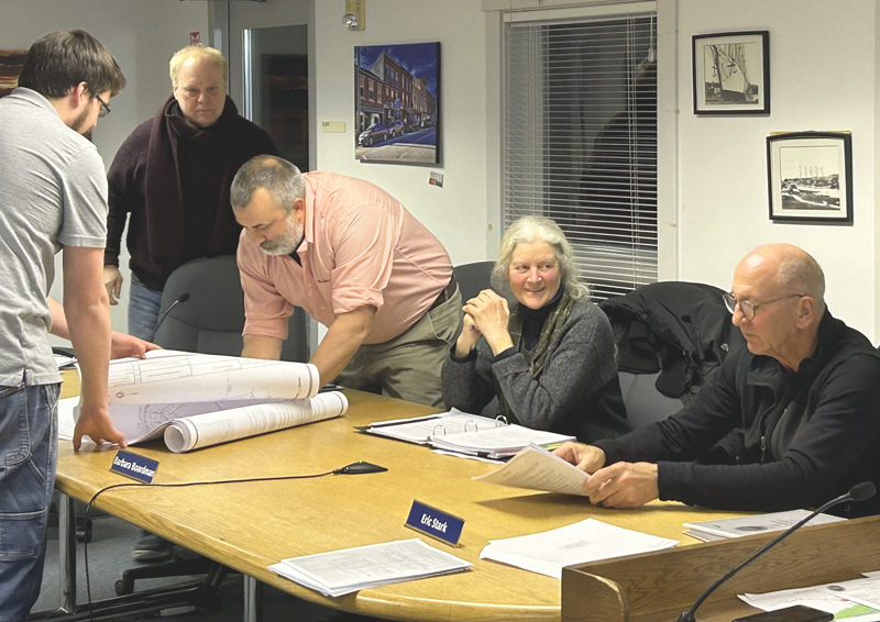From left: Town Planner Maxwell Johnstone assists Waldoboro Planning Board members John Kosnow, Brendan McGuirl, Barbara Boardman, and Eric Stark in signing the official copies of a 98-acre subdivision planned for Old Augusta Road. (Molly Rains photo)