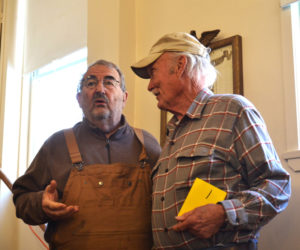 Although they disagreed on the merits of the special town meeting warrant article, Westport Island residents Mario DePietro (left) and Bill Hopkins discuss the issue in a neighborly fashion after casting their ballots Saturday, Feb. 24. (Charlotte Boynton photo)