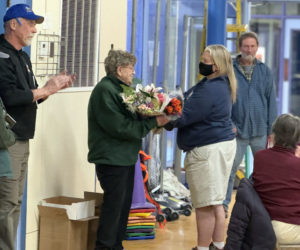 Bristol Parks and Recreation Director Shelley Gallagher (right) hands Bristol Parks and Recreation Commissioner Sandra Lane a bouquet of flowers during the annual town meeting at Bristol Consolidated School on Tuesday, March 19. This years report was dedicated to Lane, who was also a school bus driver for many years in the area. (Johnathan Riley photo)