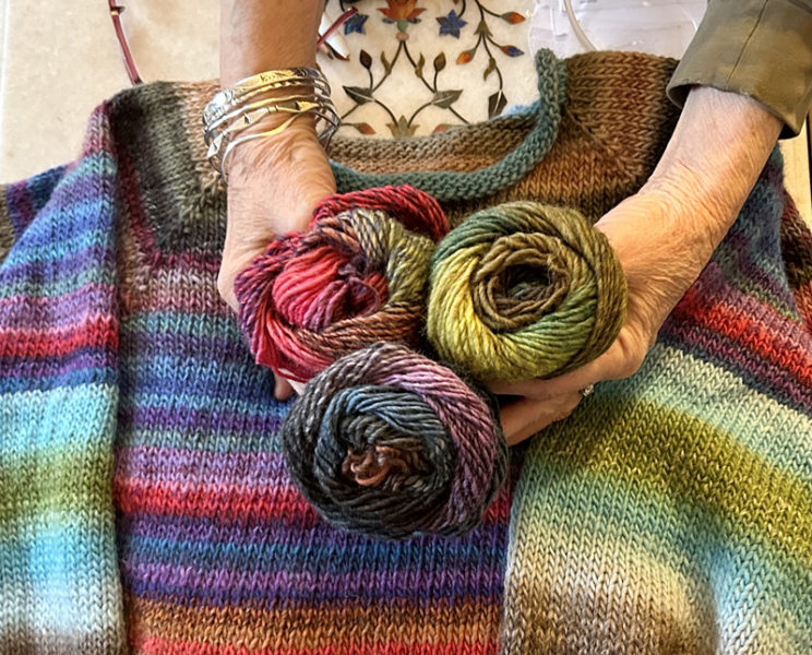 Patsy Dufresne, of Damariscotta, holds the multicolored skeins of yarn that she uses to make her "traveling sweaters" that impress fiber-art enthusiasts in the area and around the world. (Molly Rains photo)