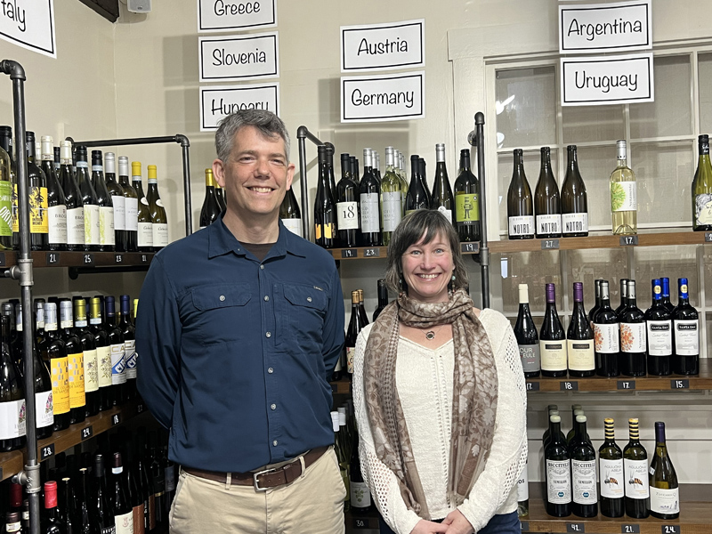 Steven Hufnagel, executive director of Coastal Rivers Conservation Trust, and Sarah Levangie, owner of Beal House, unveil an eco-friendly collaboration. Proceeds from wine sales will support Coastal Rivers' conservation efforts. (Courtesy photo)