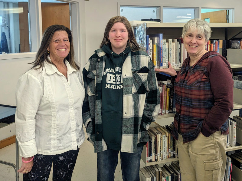 Medomak Valley High School student Teagan Aiken (center) is named the first place winner of the Last Monday of the Month Writing Challenge by judges Norma Hunt (left) and Heather Webster. (Photo courtesy Melissa Barbour)