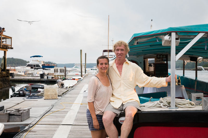 Damariscotta River Cruises co-owners Olga Oros and Chip Holmes pose next to their vessel, the Teciani, one of four boats they have docked at Schooner Landing Restaurant and Marina in August 2023. The couple is celebrating 10years of trips on the Damariscotta River this summer aboard the Teciani. (Courtesy photo)