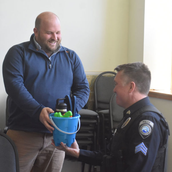 Damariscotta Town Manager Andy Dorr (left) presents Sgt. Erick Halpin with a going-away gift of beach items during a celebration at the town office on Tuesday, May 7. Halpin, who joined the Damariscotta Police Department in October 2014, worked his last shift on May 7. (Maia Zewert photo)