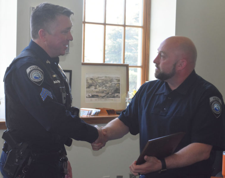 Damariscotta Police Chief Jason Warlick (right) shakes hands with Sgt. Erick Halpin at the town office on Tuesday, May 7. The Damariscotta Police Department, town office staff, and members of the Damariscotta Select Board gathered to honor Halpin on his last day. (Maia Zewert photo)