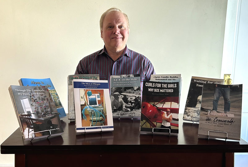 John Kosnow displays the nine titles he has authored on topics ranging from recovering from being hit by a car and using powerlifting as an emotional outlet. Kosnow said that when inspiration strikes, he just starts writing and lets the book take shape. (Molly Rains photo)