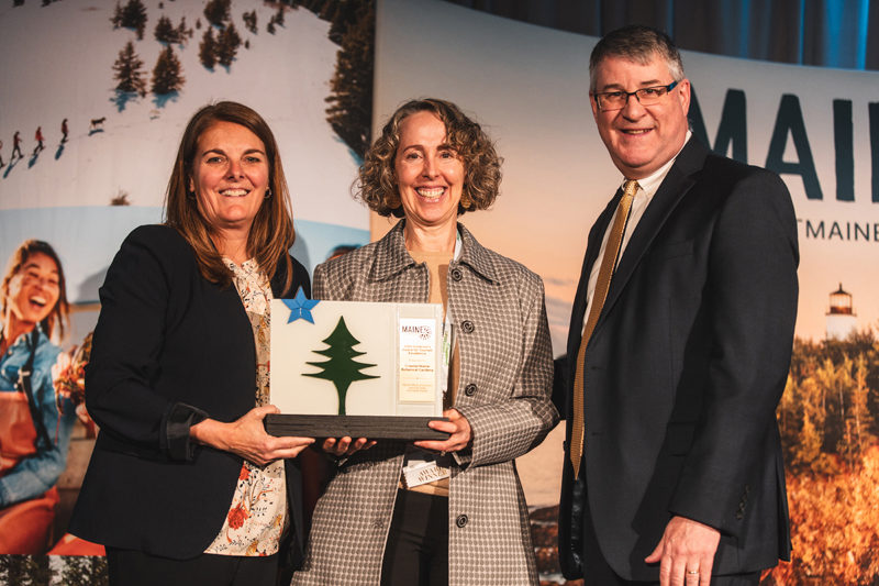 Maine Department of Economic and Community Development Commissioner Heather Johnson (left) and Maine Office of Tourism Director Steve Lyons present the Governors Award for Tourism Excellence to Coastal Maine Botanical Gardens President and CEO Gretchen Ostherr, and (Photo courtesy Coastla Maine Botanical Gardens)