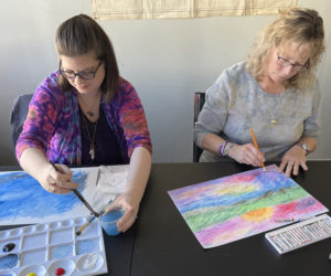 Lauren Woodcock (left) and Sharon Bailey (right) at work during a How Music Helps art workshop held earlier this year at Lincoln County Recovery Community Center. (Photo courtesy Peter Bruun)