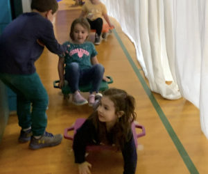 Students roll through a makeshift scooter wash while learning safe scooter skills in physical education class at Nobleboro Central School last week. (Photo courtesy Nobleboro Central School)