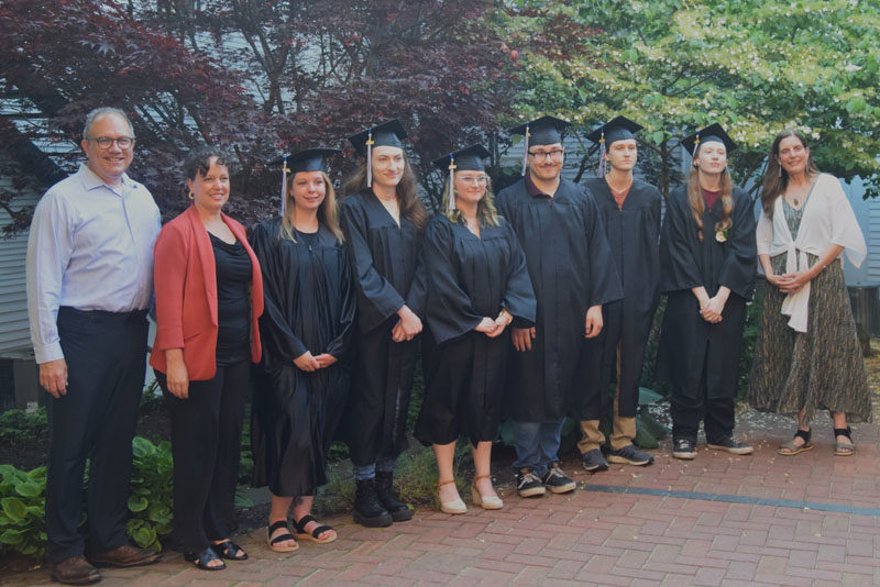 From left: Central Lincoln County Adult Education Director David Watts, AOS 93 Superintendent Lynsey Johnston, graduates Nicole Pratt, Mason Fordham, Lily Schutte, Anthony Roman, James Rackliffe, Trevor Anderson, and CLC instructor Elizabeth Potter pose for a photo at Skidompha Library in Damariscotta after graduation Tuesday, June 11. (Nolan Wilkinson photo)