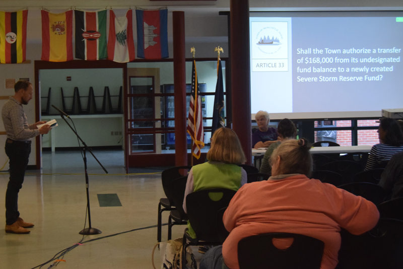 Town Manager Kevin Sutherland (left) explains the severe strom reserve fund to residents at the Monday, June 17 annual town meeting at Lincoln Academy. (Nolan Wilkinson photo)