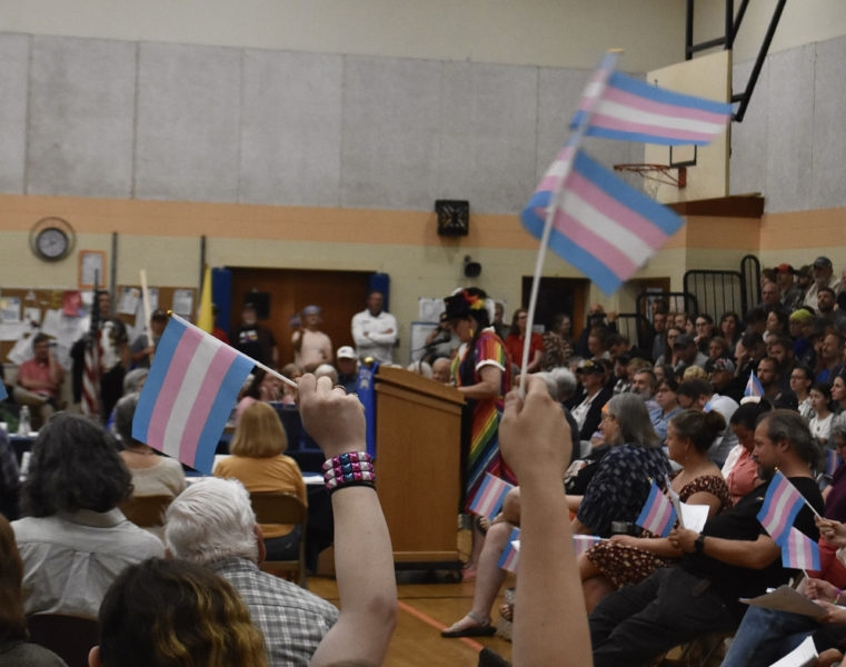 Audience members wave pride flags while Rachel Genthner, of Waldoboro, speaks to the RSU 40 Board of Directors on Thursday, June 6. "I hope you'll open your hearts and think twice before causing hatred," Genthner said. (Molly Rains photo)