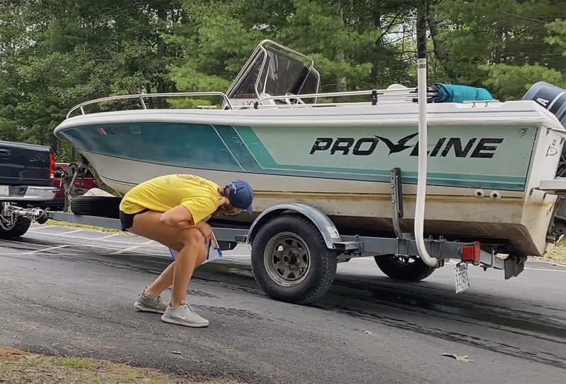 With permission, a courtesy boat inspector looks over a boat at the Pemaquid Pond boat landing in Nobleboro. (Photo courtesy Coastal Rivers Conservation Trust)