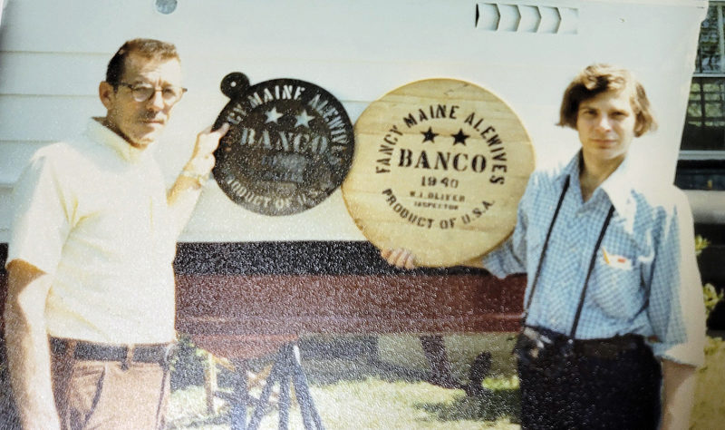 Earle McLean, left, with the alewife stencil he gave to the Nobleboro Historical Society, and George Derringer holding the stenciled alewife barrelhead. (Photo courtesy Nobleboro Historical Society)