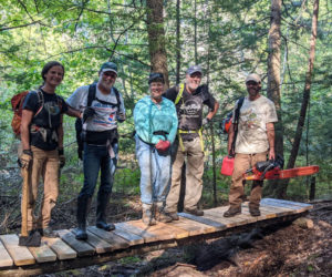 From left, volunteers Isobel Curtis, Jim Node, Susan Cottle, Bill Brooke, and Tim Libby test a newly built bridge at Trout Brook Preserve in Alna last September. (Photo courtesy Isobel Curtis)