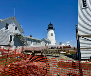 Pemaquid Point Lighthouse overlooks the bell house construction site on Thursday, June 27. In addition to repairs to the bell house, the eastern wall of the building attached to the lighthouse had its siding replaced and the white picket fence was recemented after sustaining damage in severe twin storms in January. (Johnathan Riley photo)