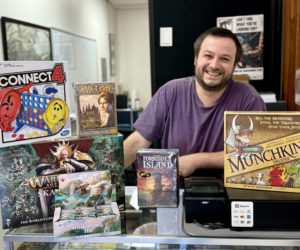 Forrest Meader stands behind the counter of his new business Mythical Market in Damariscotta on Friday, July 19. Meaders new business is a tabletop game shop selling popular card games like Magic: The Gathering and board games like Settlers of Catan. (Johnathan Riley photo)