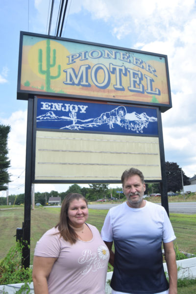 Shantel Sauvie stands with her father, Pioneer Motel owner Jim Sauvie in front of his business sign on Route 1 in Edgecomb on Tuesday, July 16, Jim Sauvie's 61st birthday. (Nolan Wilkinson photo)