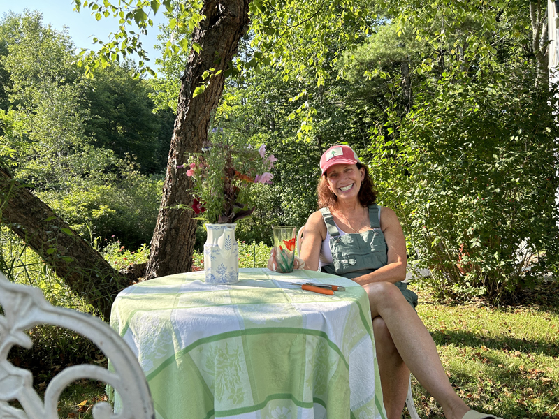 Waldoboro flower farmer Ann Marie Gallant sits with a bouquet while taking a short break from tending her flower fields on Sunday, July 14. Gallant, who is also a painter, started flower farming in 2019 and hasn't looked back since. "It's all about beauty," she said. (Molly Rains photo)