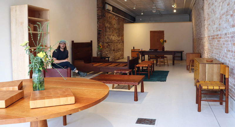 Brian Christopher, owner of Bicyclette Furniture, sits among his creations in the company's new showroom at 78 Main St. in Wiscasset on Thursday, July 11. Christopher opened the showroom to the public on July 4. (Photo by Piper Pavelich)