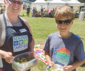 Healthy Lincoln County SNAP educator Samantha Mehlhorn (left) and local student enjoy a summer salad at the Damariscotta Farmers Market. (Photo courtesy Healthy Lincoln County)