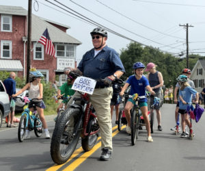 Former Bristol Fire Chief Paul Leeman leads a brigade of children on bikes during the Olde Bristol Days parade in New Harbor on Saturday, Aug. 10. The brigade entered the parade at Harbor Ice Cream on Route 130. (Johnathan Riley photo