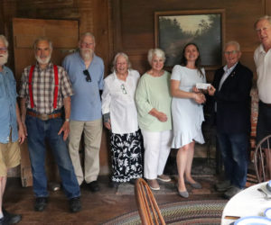 From left: Dave Probert, Chuck Vaughan, Greg Edwards, Perry Palmer, Robin Grant, Lincoln County Historical Association Executive Director Shannon Gilmore, Maine Antiques Dealers Association endowment fund chair Harry Hepburn, and Christopher Stanley stand in front of a landscape painting by Henry Cheever-Pratt in Dresden's Pownalborough Court House on Wednesday, July 31. The Maine Antiques Dealers Association donated $1,000 to the Lincoln County Historical Association to help cover the cost of the painting's restoration. (Piper Pavelich photo)