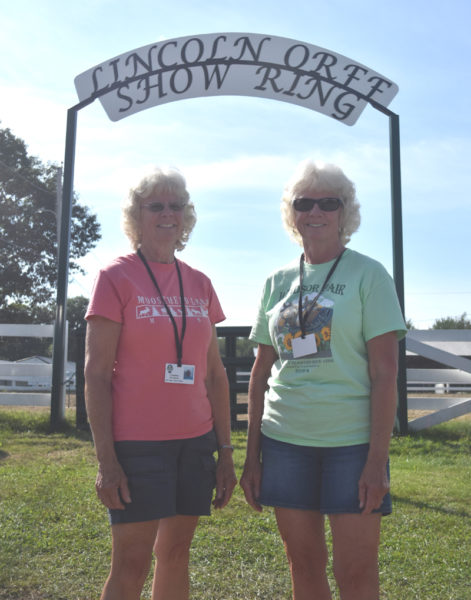 Claudene Northrup (left) and Claudia Orff-Reed, sisters from Jefferson, stand at the Lincoln Orff Show Ring, which is named for their father, who passed away in 2021. Orff was secretary at the Windsor Fair for more than 30 years and well known for the show steers he raised, trained, and showed with Orff-Reed and Northrup. (Molly Rains photo)