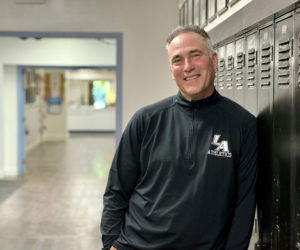 Lincoln Academy Headmaster Jeff Burroughs leans against lockers at the school in Newcastle on Thursday, Aug. 22. In addition to being the schools headmaster, Burroughs is the boys varsity soccer coach and an avid fly fisherman. (Johnathan Riley photo)